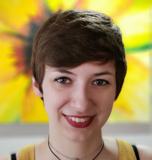 headshot of woman with short hair smiling against yellow background