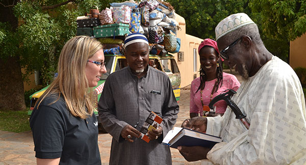Blonde woman and 2 men and 1 woman from Mali talking