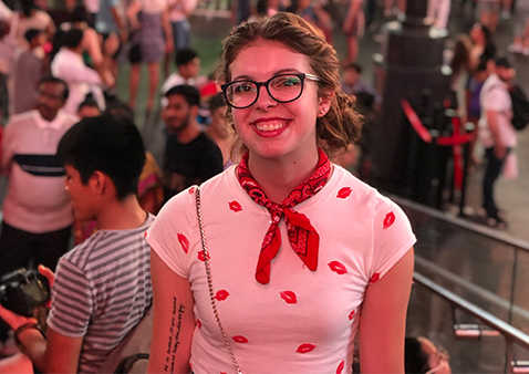 a girl with a white and red shirt wearing glasses and a red neck scarf