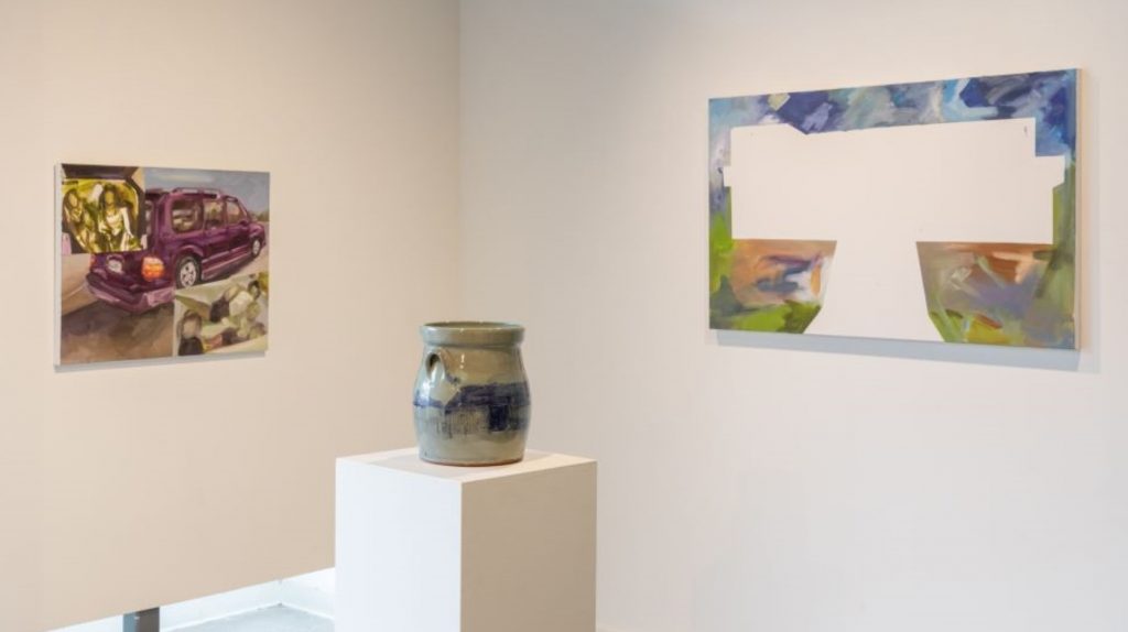 art gallery with two paintings and a ceramic work in the center