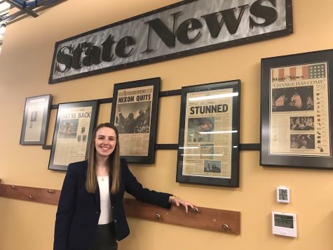 woman standing in front of the state news sign