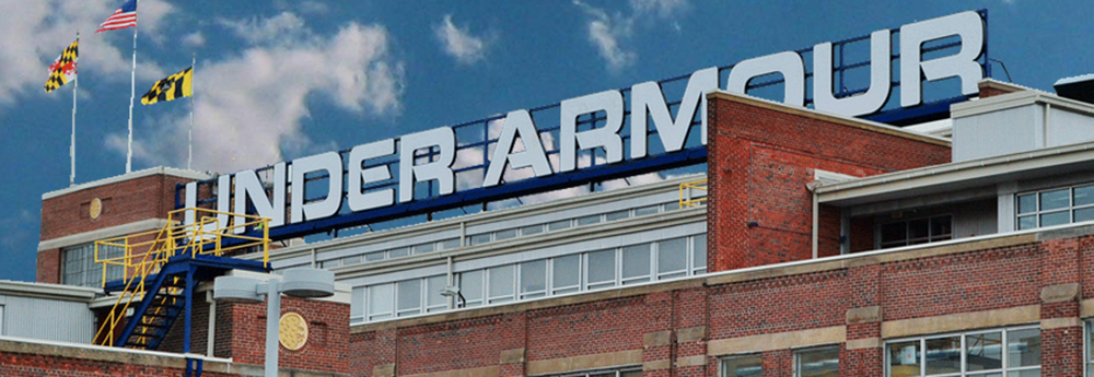 a sign on top of a red brick building that reads "under armour"