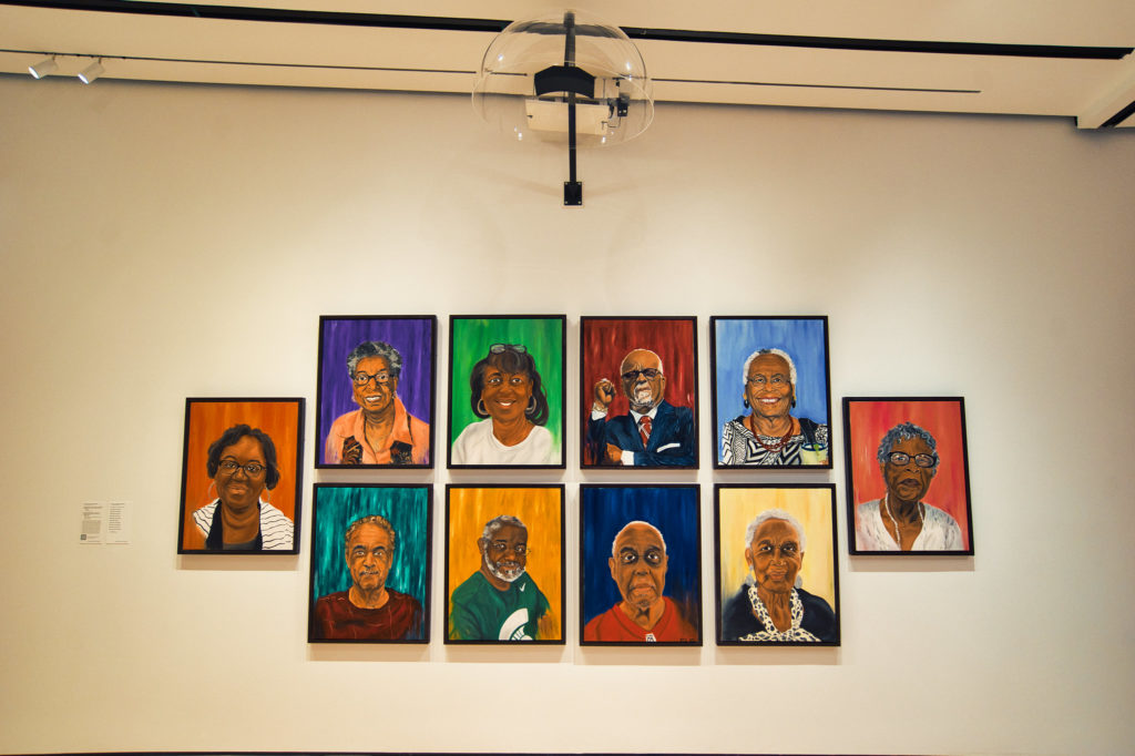 A picture of a series of portraits hanging below a plastic dome.