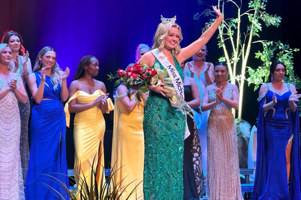 Photo of Maya Schuhknecht, being crowned Miss Michigan 2023 in front of the other contestants. 