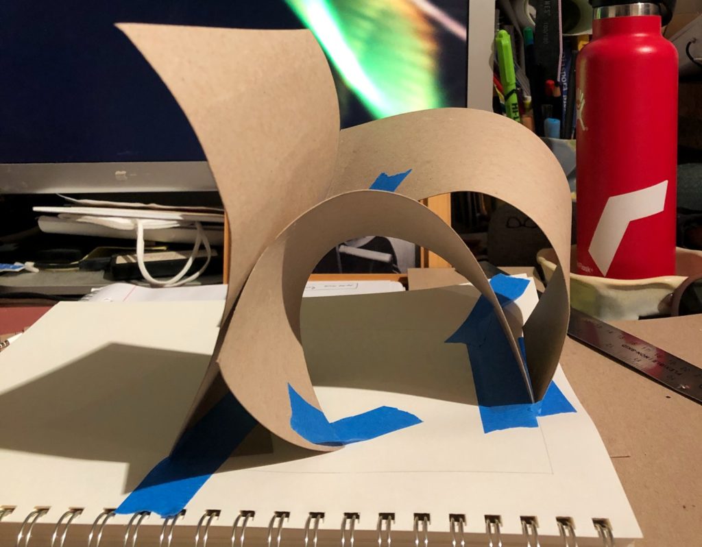 A picture of a paper sculpture taped to a notebook.