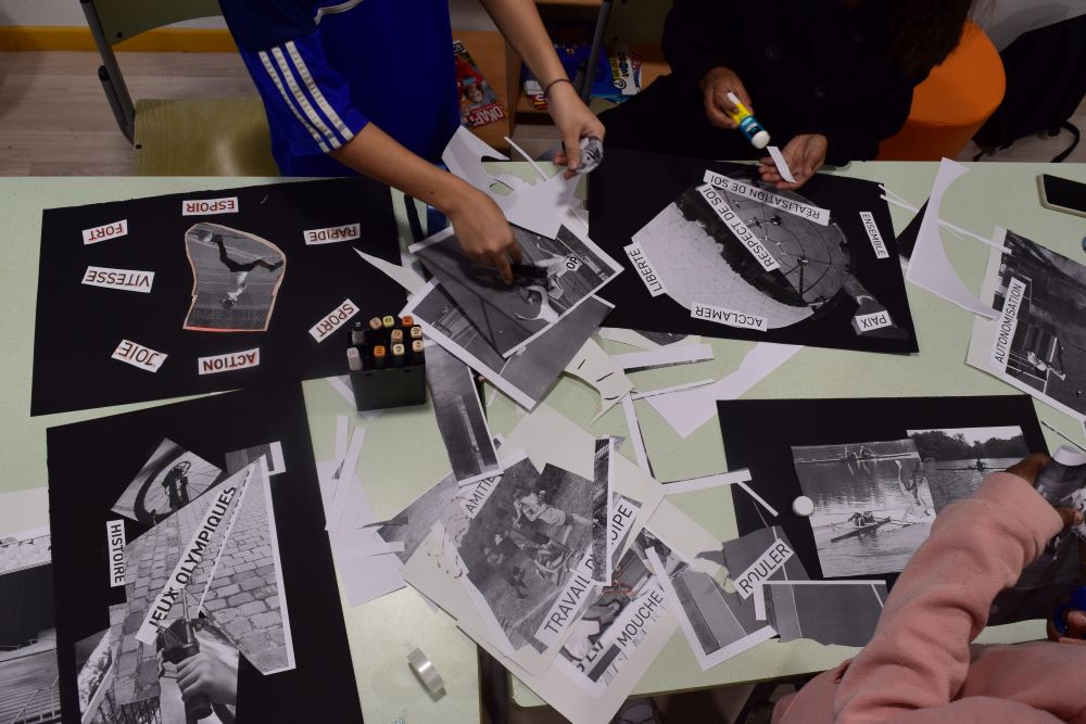 A table showing of different collages made up of photos and words. Children's hands work on the collages.