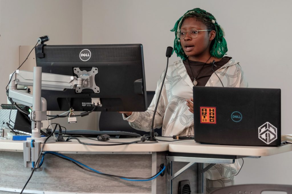 woman standing at computer and speaking.